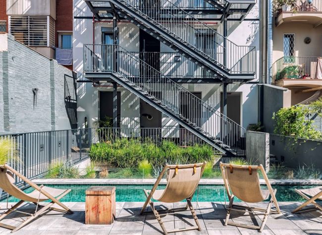 Patio del Hotel Brummel con piscina, tumbonas y parterres